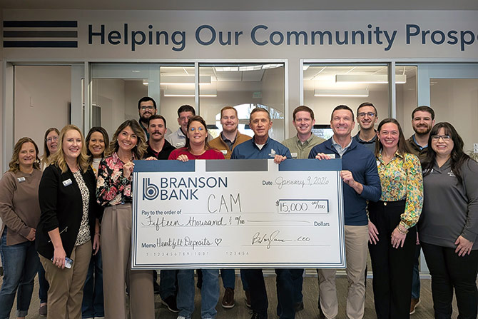 Bank employees holding large check for $15,000