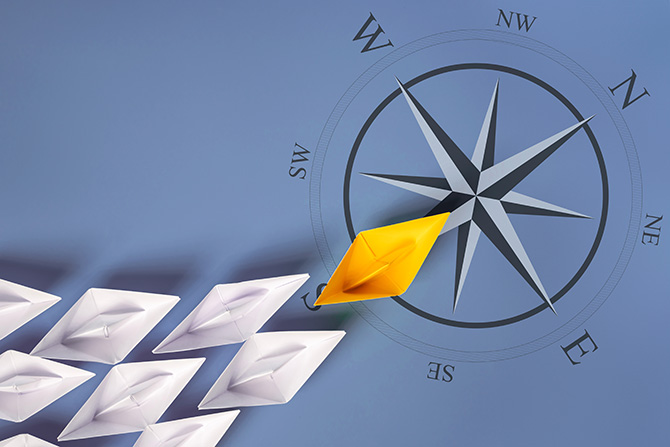 Paper boats on top of compass