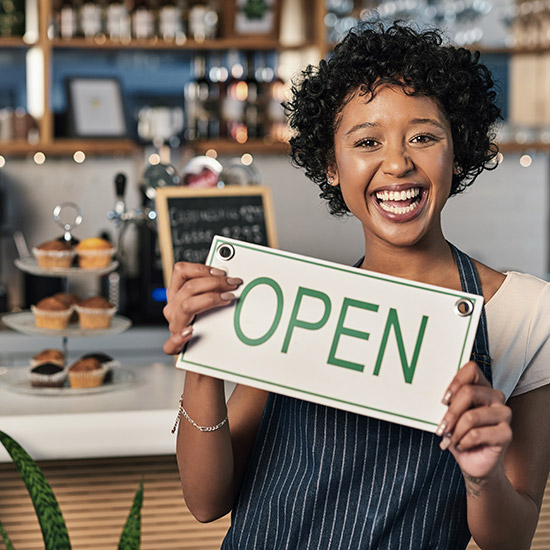 small business owner holding the "open" sign